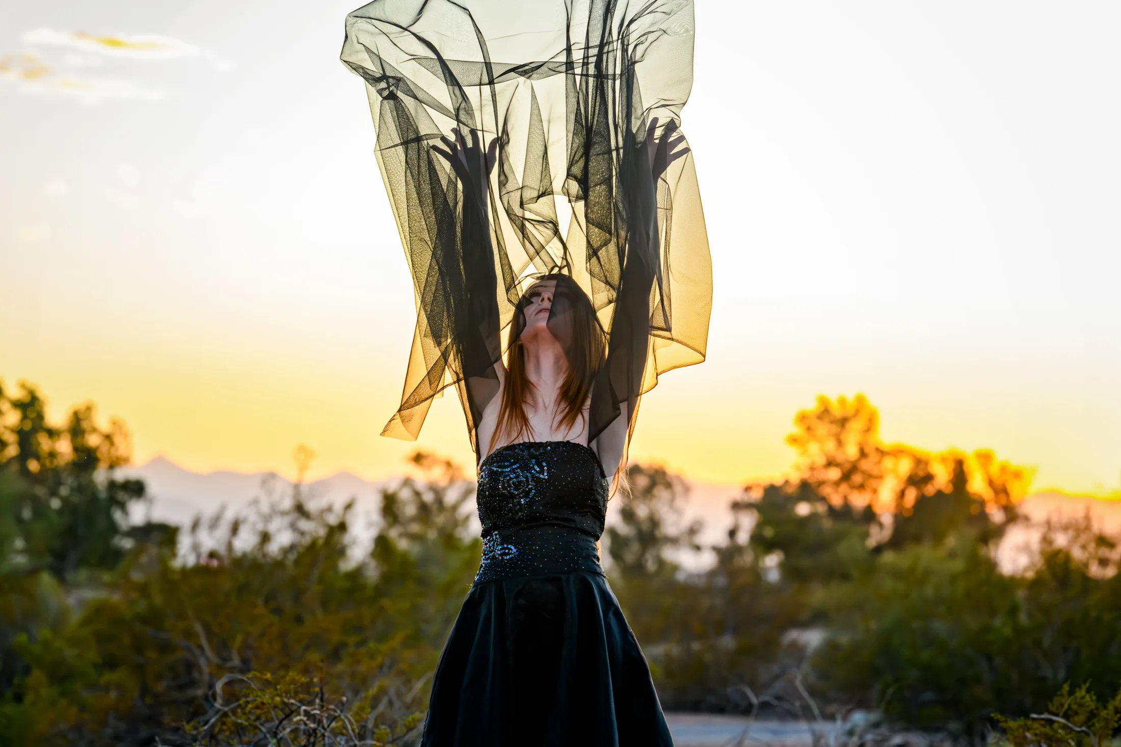 Black fabric suspended in the air against the sunset.